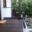 Balcon avec garde-corps noir en verre et terrasse en bois foncé Garde-corps noir en verre avec main courante installé sur un petit balcon extérieur avec terrasse en bois foncé.